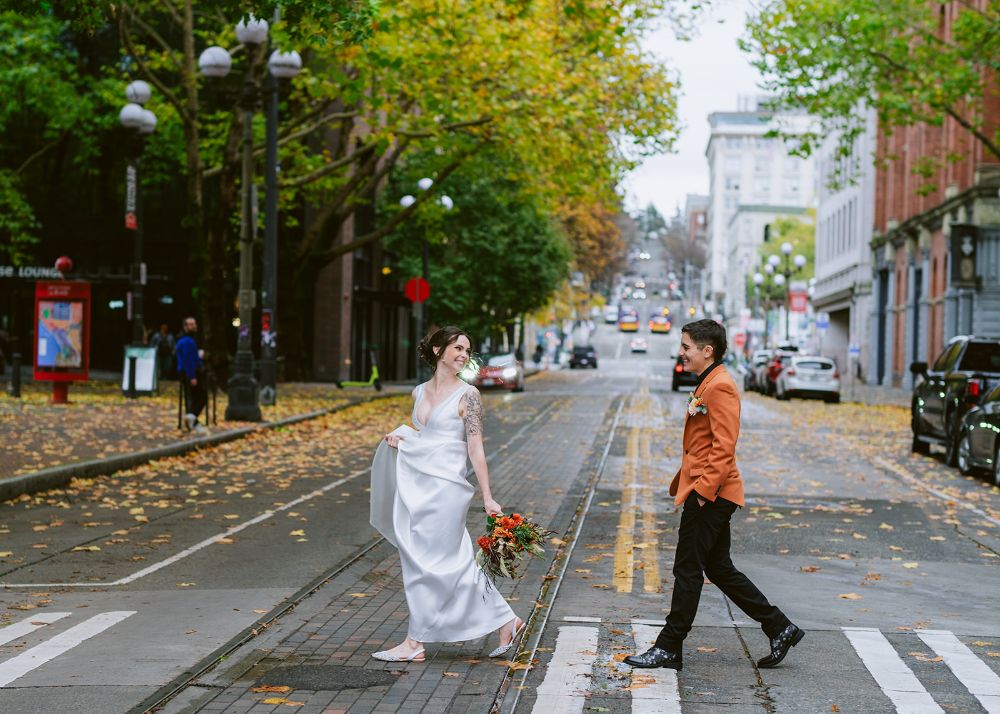 Riley and Alex stroll across the street at their Seattle wedding