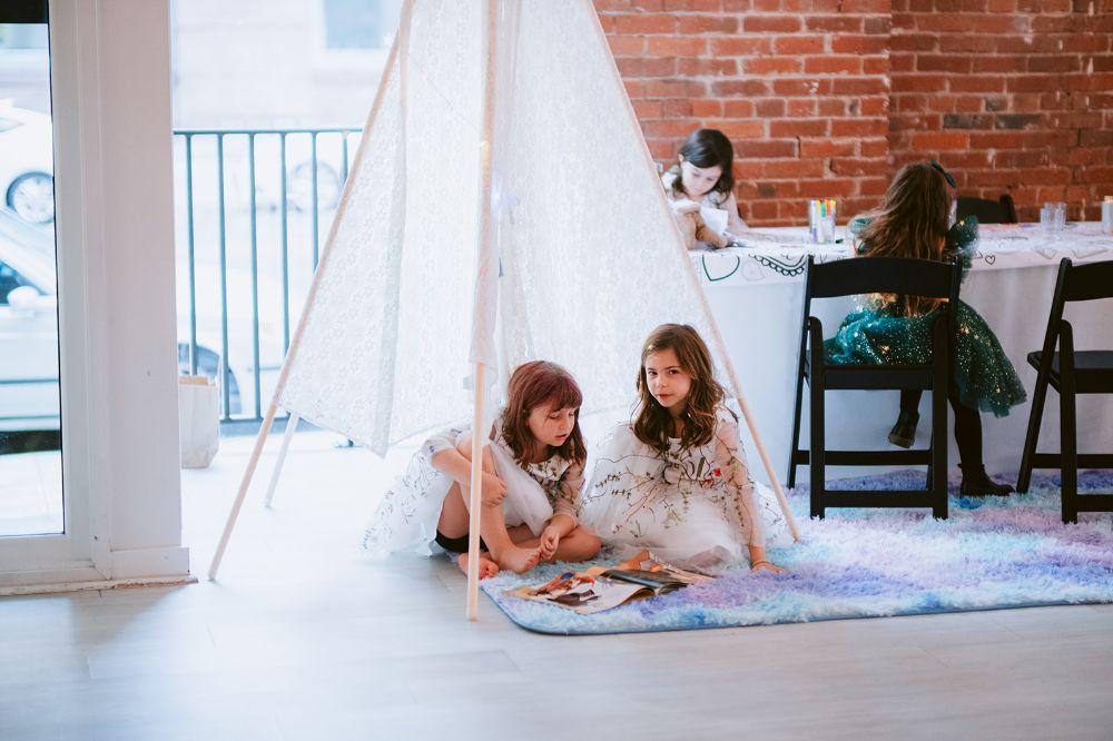 Kids play in a teepee tent at their parent's Seattle wedding