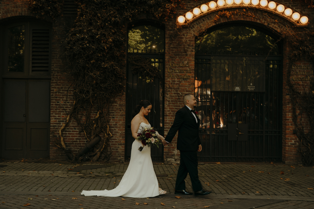 Bride and groom walking through Pioneer Square, Seattle