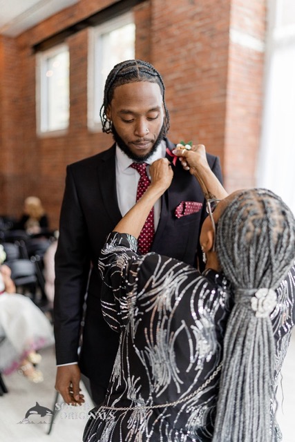 Bride's son receiving his boutenniere