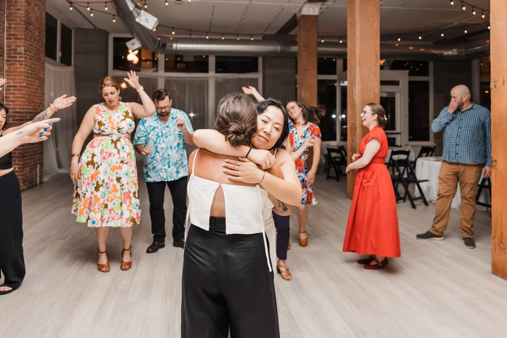 Brides hugging on their wedding day at THE 101 in Seattle