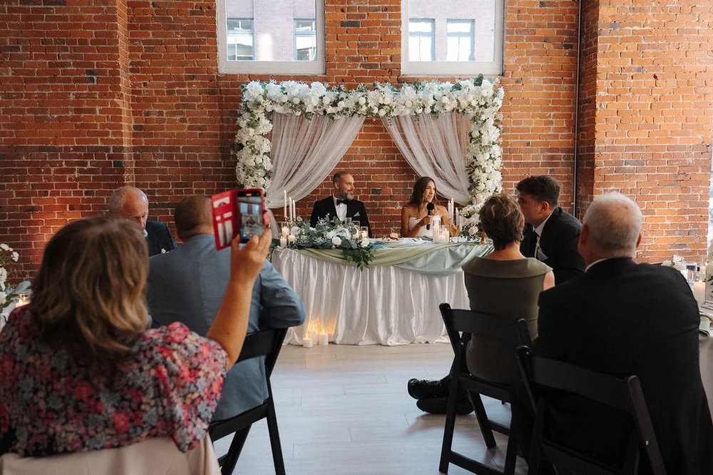 Bride and groom sitting at their sweetheart table at THE 101 in Seattle, WA
