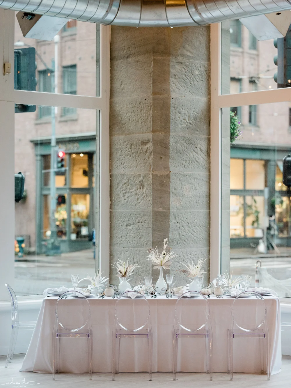Holiday party table set up at THE 101 Seattle with white linens, ghost chairs, and white floral and table decor.