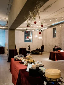 Holiday party at THE 101 with deep red linens, florals, and a buffet setup.