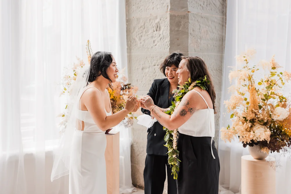 Two brides saying their vows at their wedding at THE 101 in Seattle
