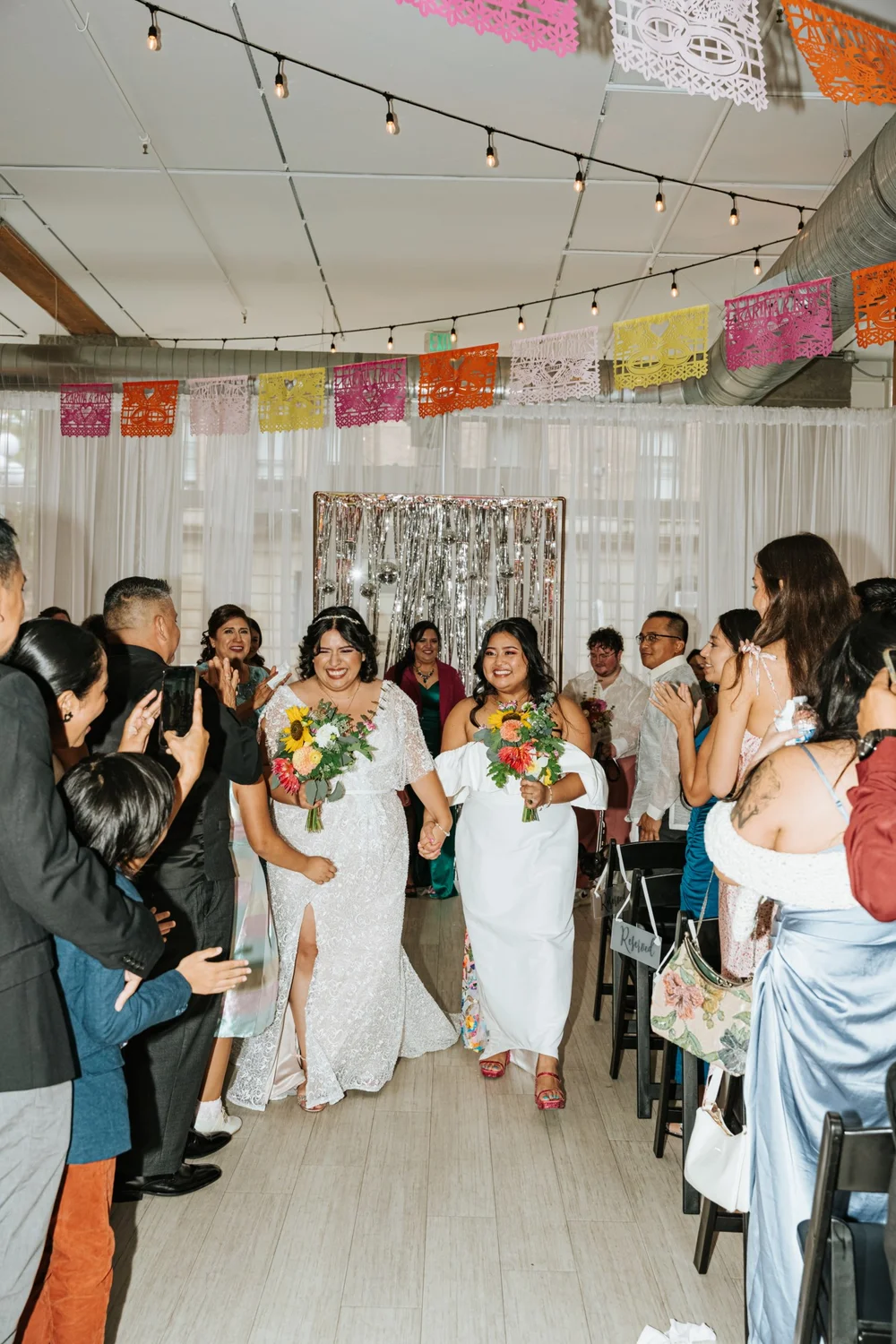 LGBTQ+ brides walking down the aisle at THE 101 wedding venue in Seattle WA